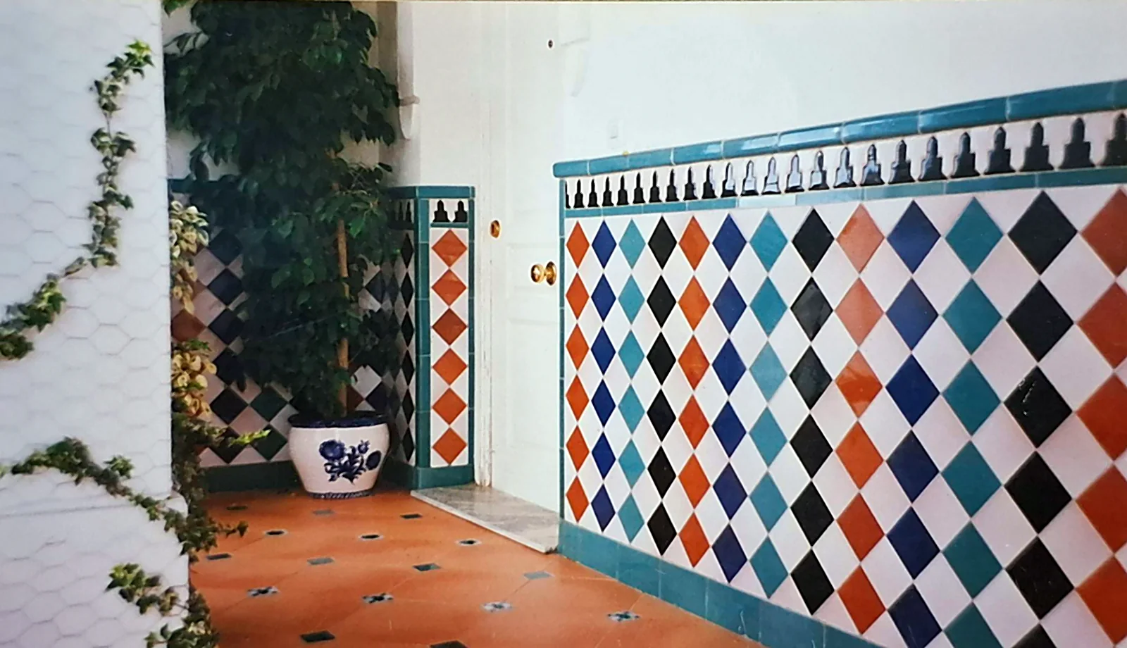 Patio en el Albaicín con zócalo de azulejos Fajalauza y suelo de terracota